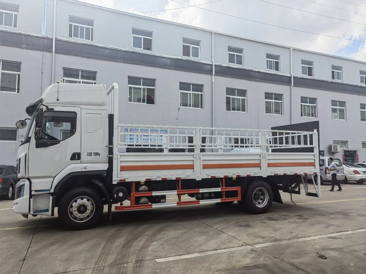 东风柳汽乘龙H5 6.72米危险品运输车 右侧正侧面实拍：白色栏板贯通 + 橙色反光带 + 可卸仓栅围栏 + 红白侧防护栏 + 总质量18000kg标识