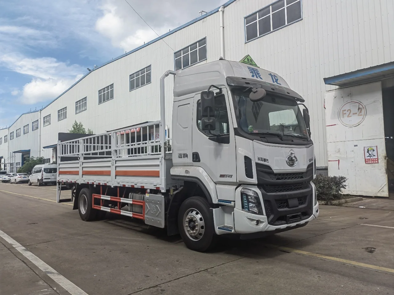 东风柳汽乘龙H5危险品仓栅运输车 右前45度实拍：白色驾驶室 + 仓栅围栏 + 橙色反光条 + 铝合金油箱 + 危险品顶灯