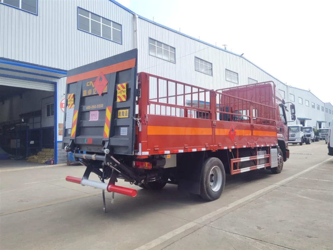 东风柳汽乘龙H5 6.72米仓栅式危险品运输车 右后45度实拍：红色驾驶室配色 + 液压升降尾板展开 + 红色栏板带橙色反光带 + 菱形危险品标志