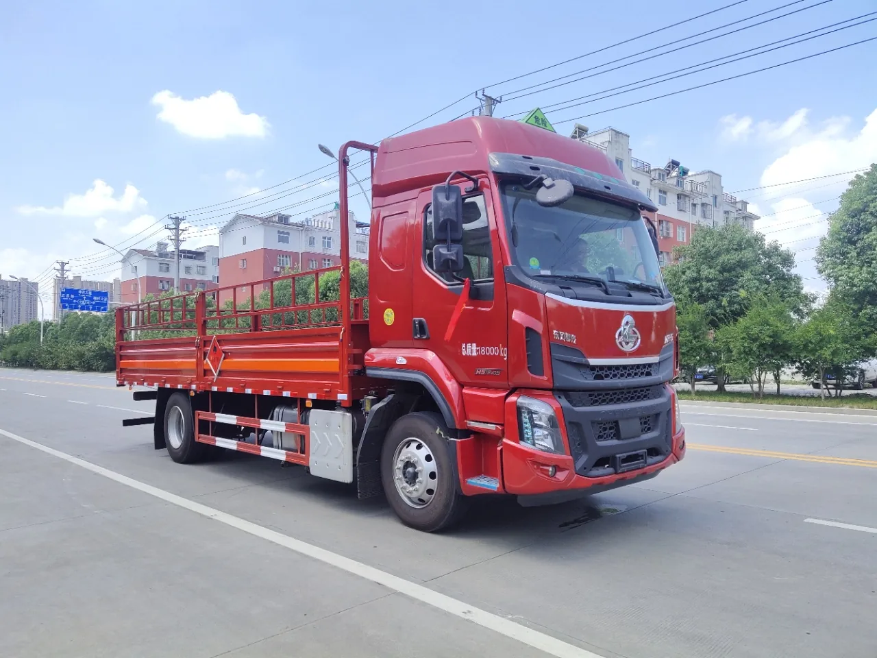 东风柳汽乘龙H5危险品仓栅运输车 左前45度实拍：红色驾驶室配色 + 危险品三角顶灯 + 红色栏板带橙色反光带 + 总质量18000kg标识