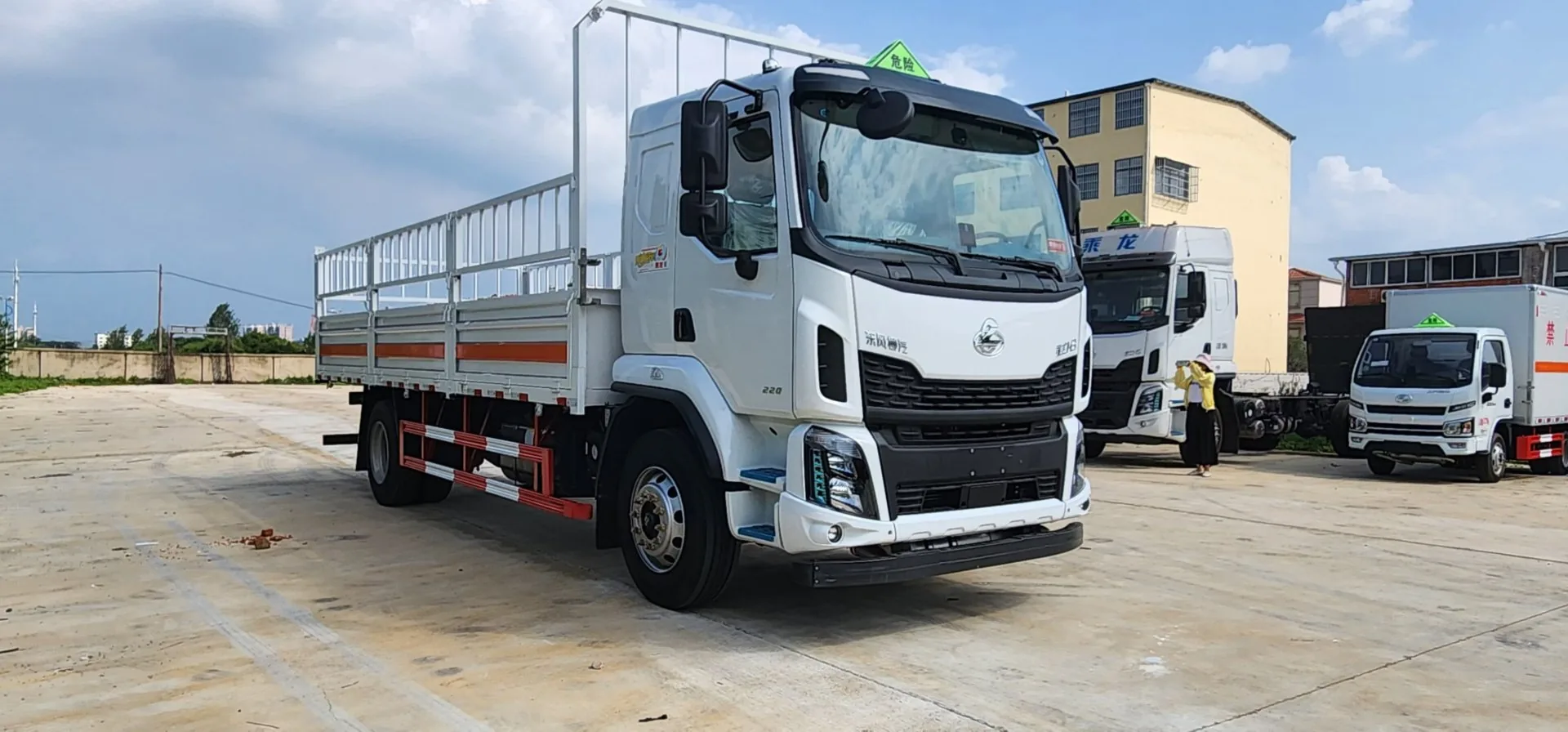 东风柳汽乘龙M3 6.8米危险品运输车 左前45度实拍：白色栏板 + 橙色反光带 + 可卸仓栅围栏 + 危险品顶灯