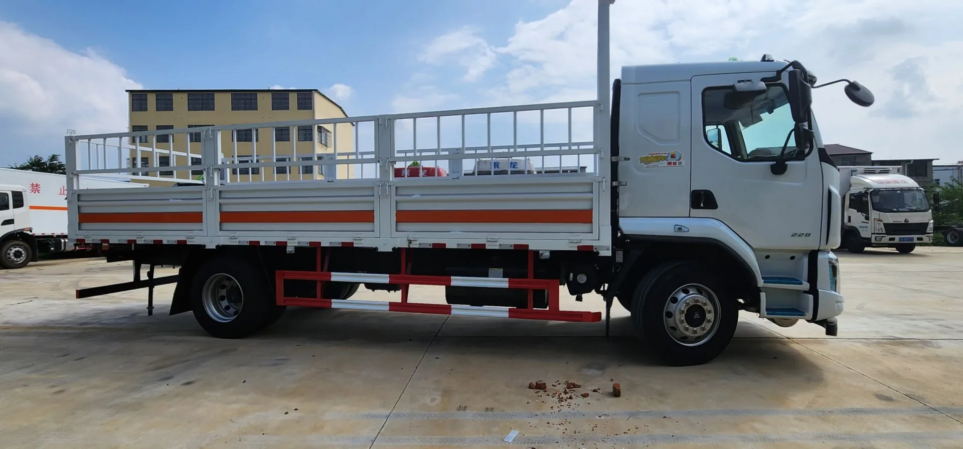 东风柳汽乘龙M3危险品仓栅运输车 右侧正侧面实拍：栏板+仓栅结构 + 橙色反光带 + 侧防护栏 + 危险品标识
