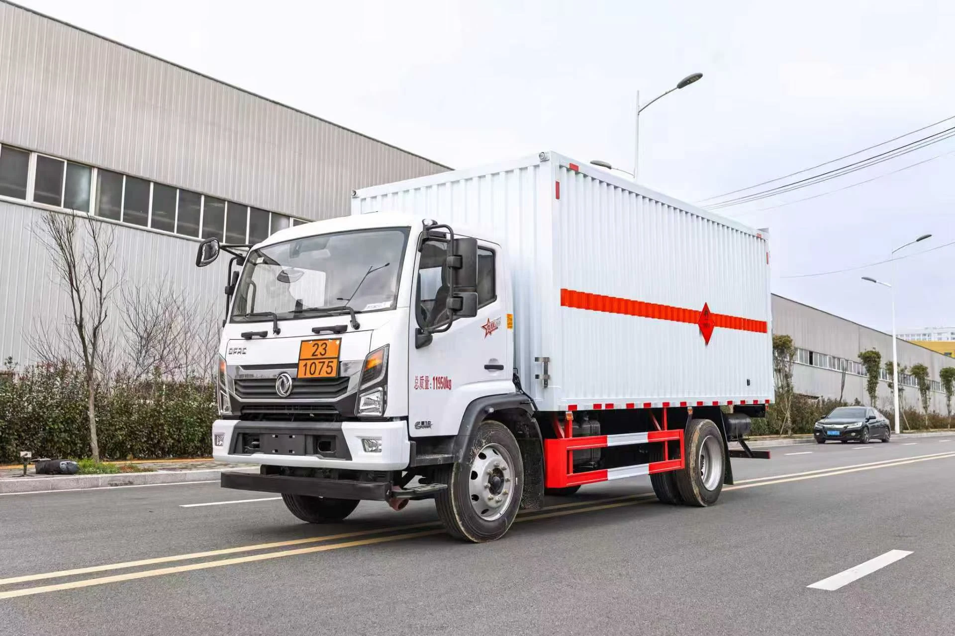 东风凯普特危化厢式车 左前45度行驶实拍：白色瓦楞厢体（百叶窗结构+橙色反光带+红色菱形标志）+ 245/70R19.5真空胎 + 红白侧防护栏 + 危险品三角顶灯