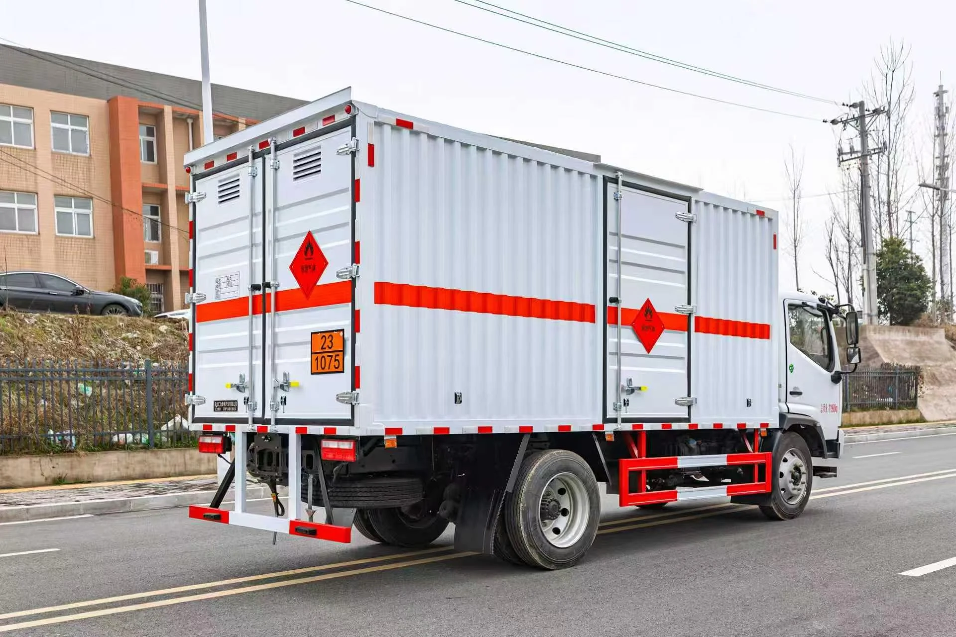 东风凯普特危化厢式车 右后45度实拍：白色瓦楞厢体后部对开门（双菱形标志：易燃气体+杂项）+ 231075临时牌照 + 尾灯及示廓灯