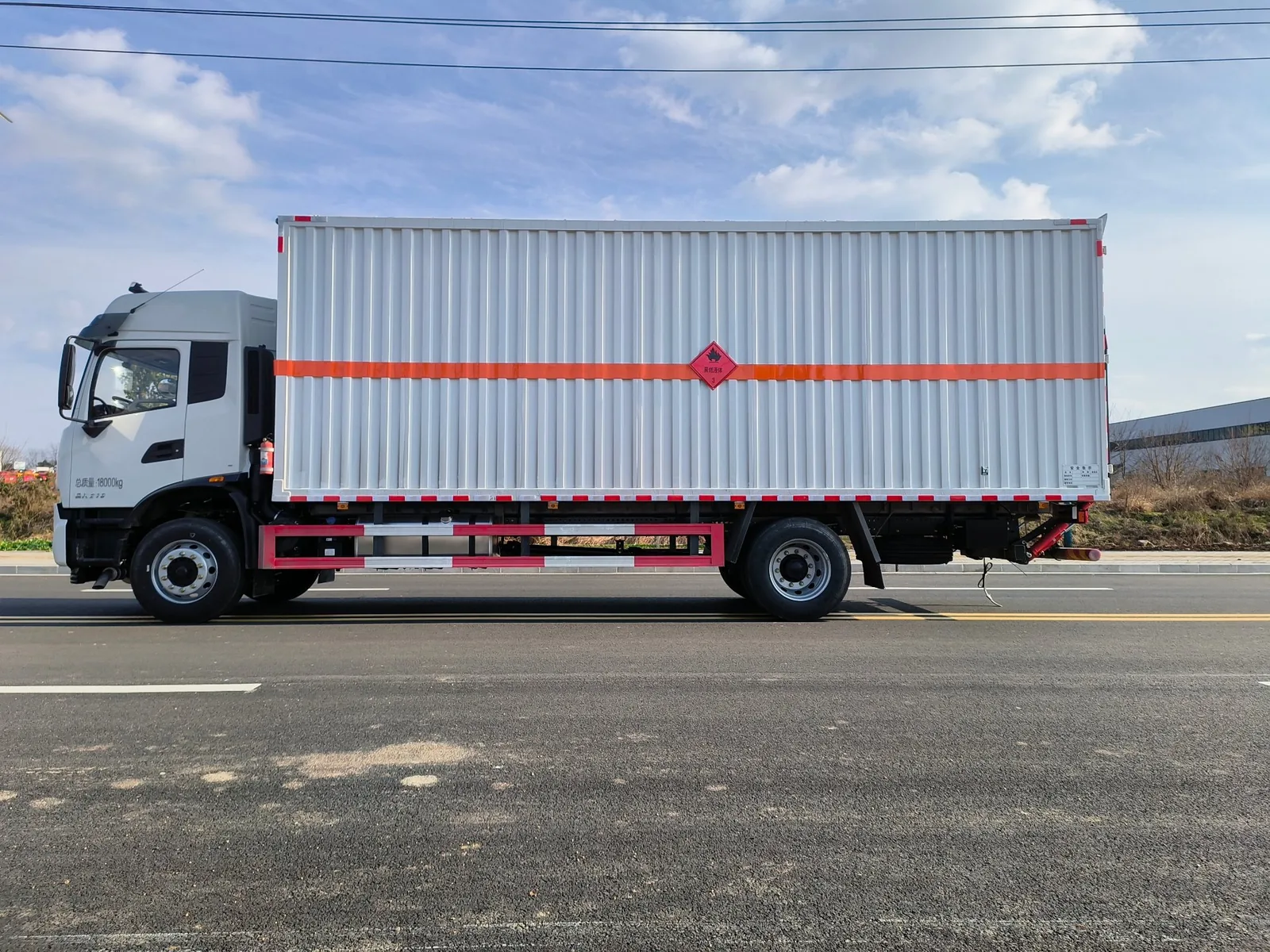东风天锦KR单桥危险品厢式运输车 DFH1180EX9 龙擎版底盘整车实拍，瓦楞板白色厢体带橙色反光带与9类菱形标识