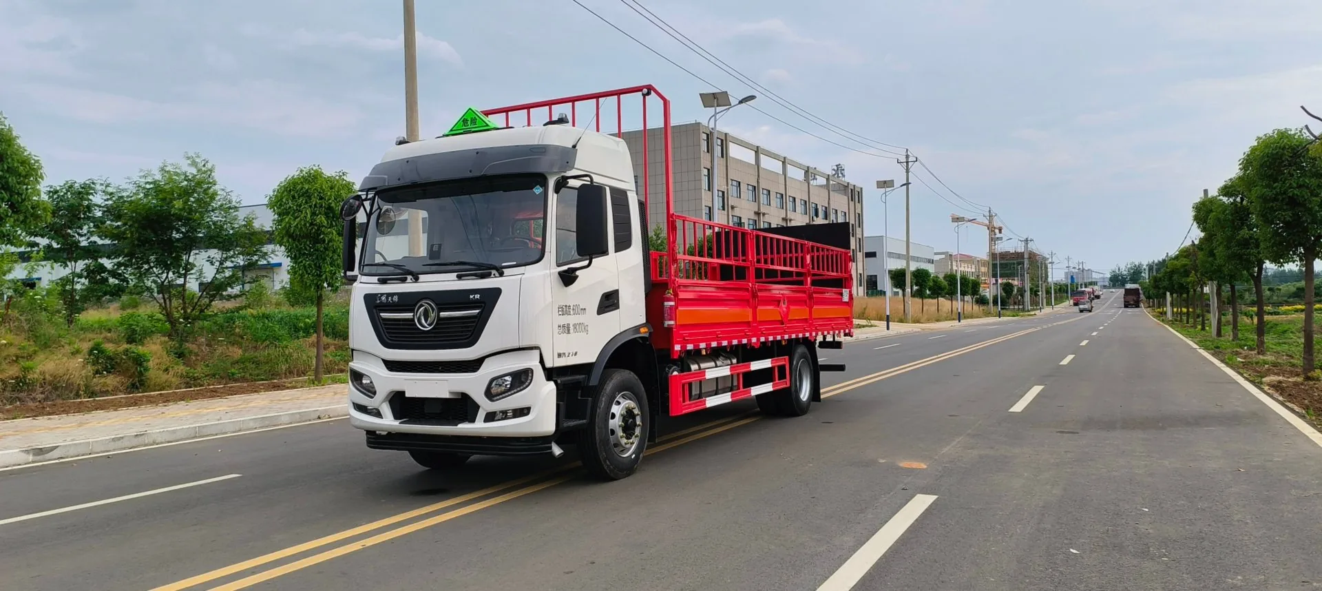东风天锦KR 6.8米高栏危险品运输车 右后45度实拍：红色仓栅 + 尾部液压尾板收纳状态 + 车厢一周反光带