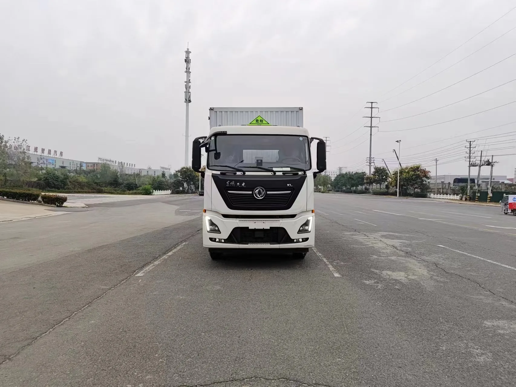 东风天龙KL危险品厢式运输车 正面实拍：D320排半驾驶室 + 东风双飞燕标 + 危险品三角顶灯 + LED日间行车灯