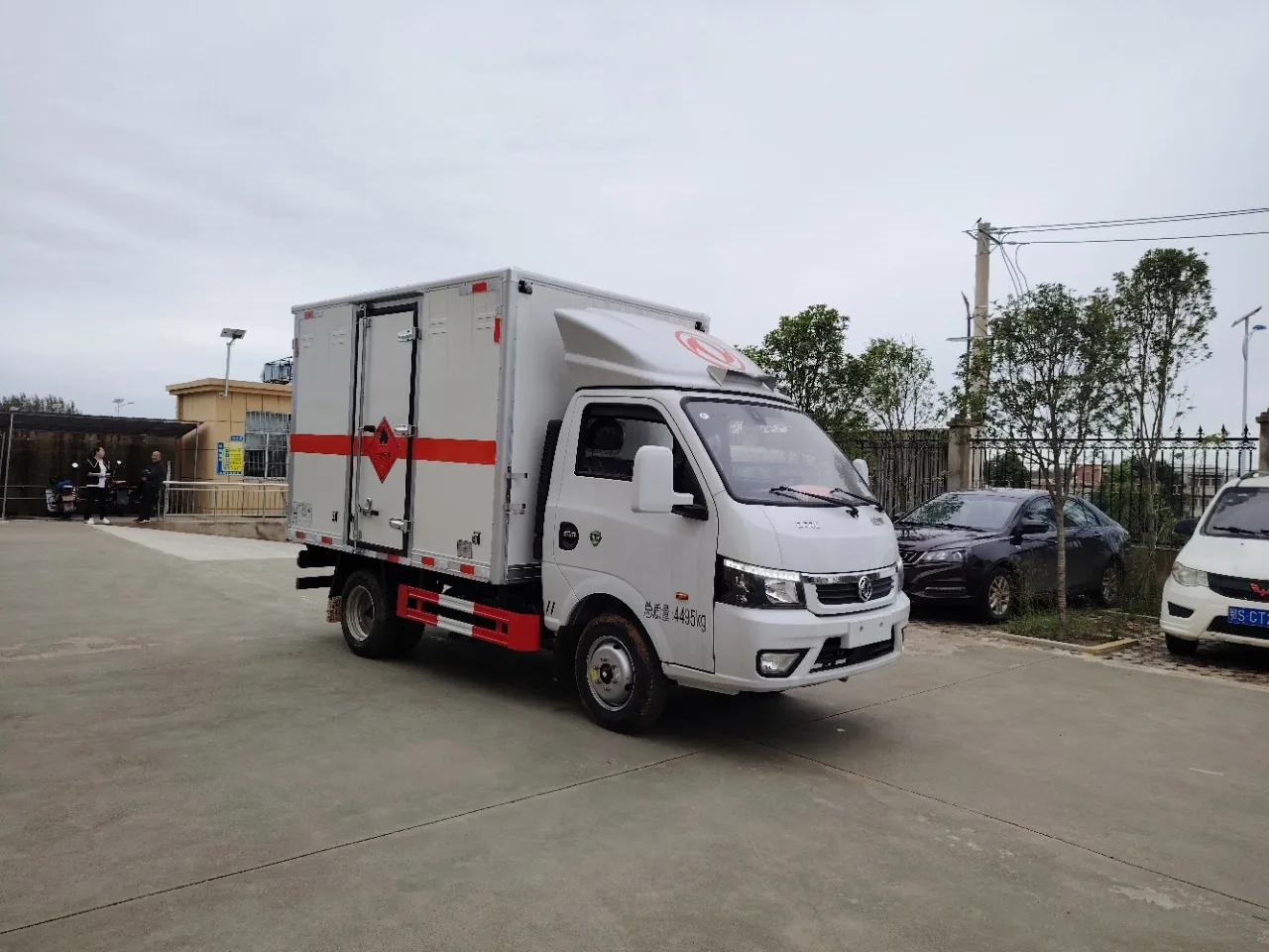 东风途逸柴油版轻型危险品厢式运输车 白色车身+白色厢体整车右前 45 度实拍，厂区外路边场景