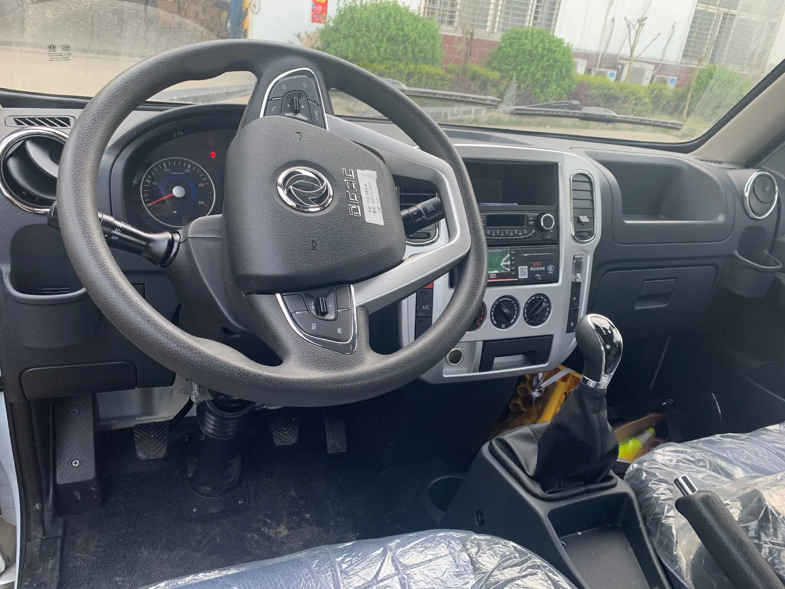 东风小途逸汽油版危险品厢式运输车 驾驶室内饰实拍，多功能方向盘、5档变速杆、空调与中控面板