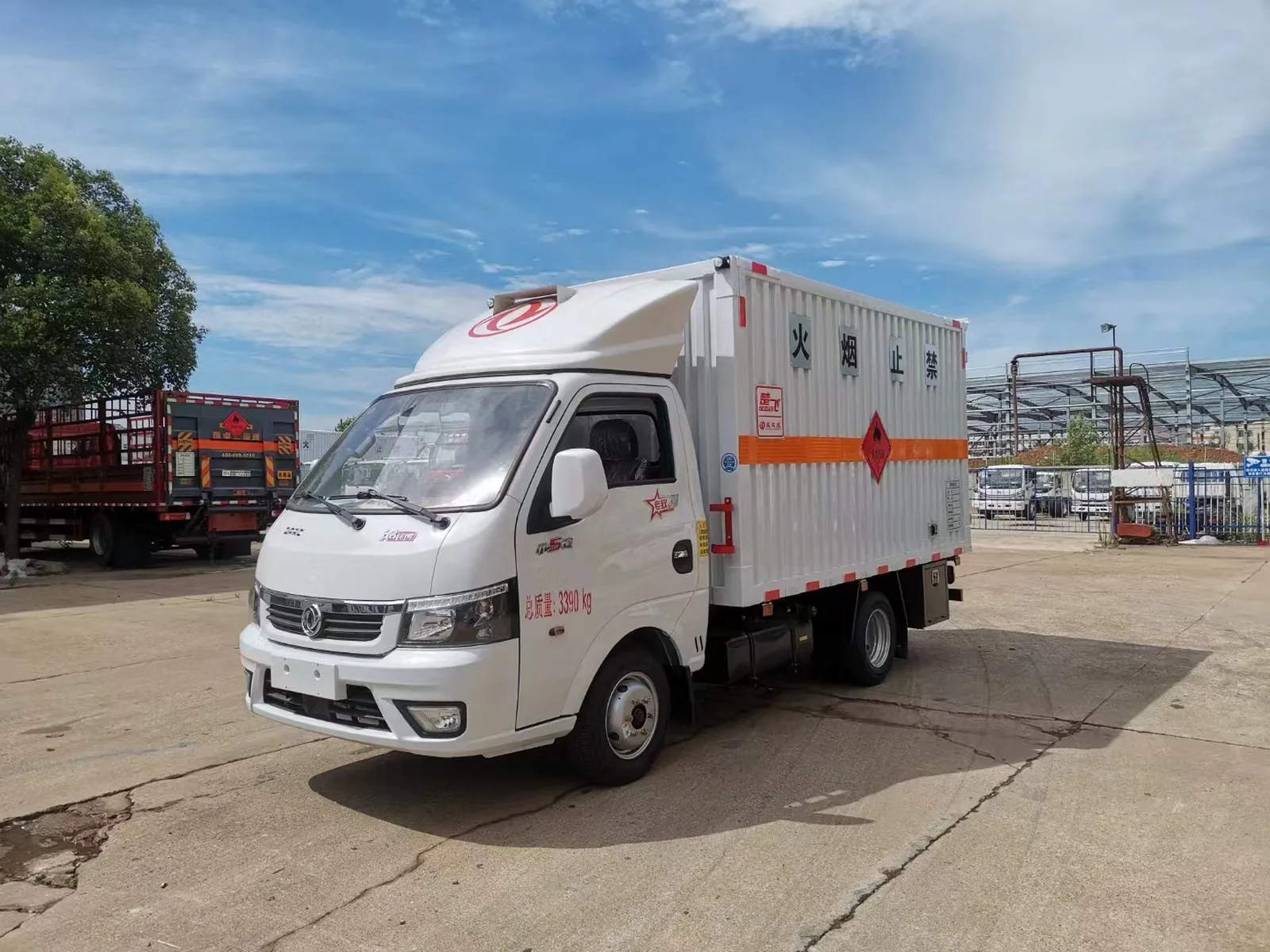 东风小途逸汽油版危险品厢式运输车 白色车身左前45度实拍，白色瓦楞厢体带橙色反光带与「总质量3390kg」标识、易燃气体菱形标