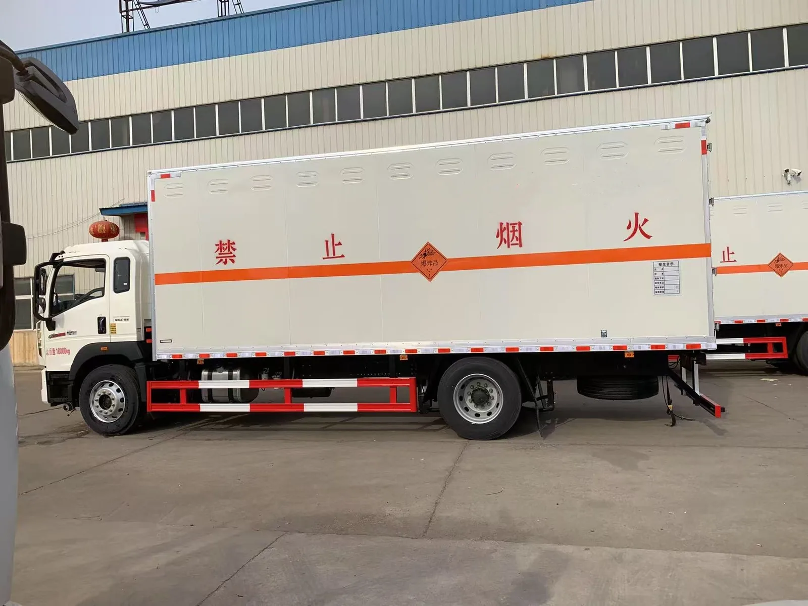 重汽豪沃单桥18吨危险品厢式运输车 左侧正侧实拍，白身白厢多开门结构与橙色反光带