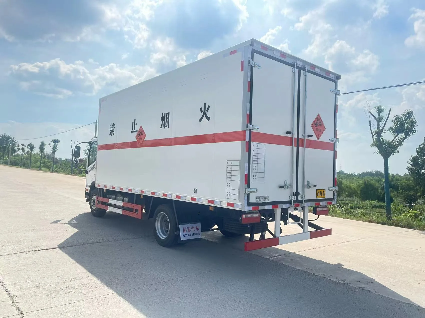 解放J6F黄牌5米5厢长爆破器材危险品厢式运输车 整车右后45度实拍：白头驾驶室 + 白色复合厢体 + 红色反光腰线 + 爆炸品菱形标识 + 禁止烟火字样 + 示廓灯