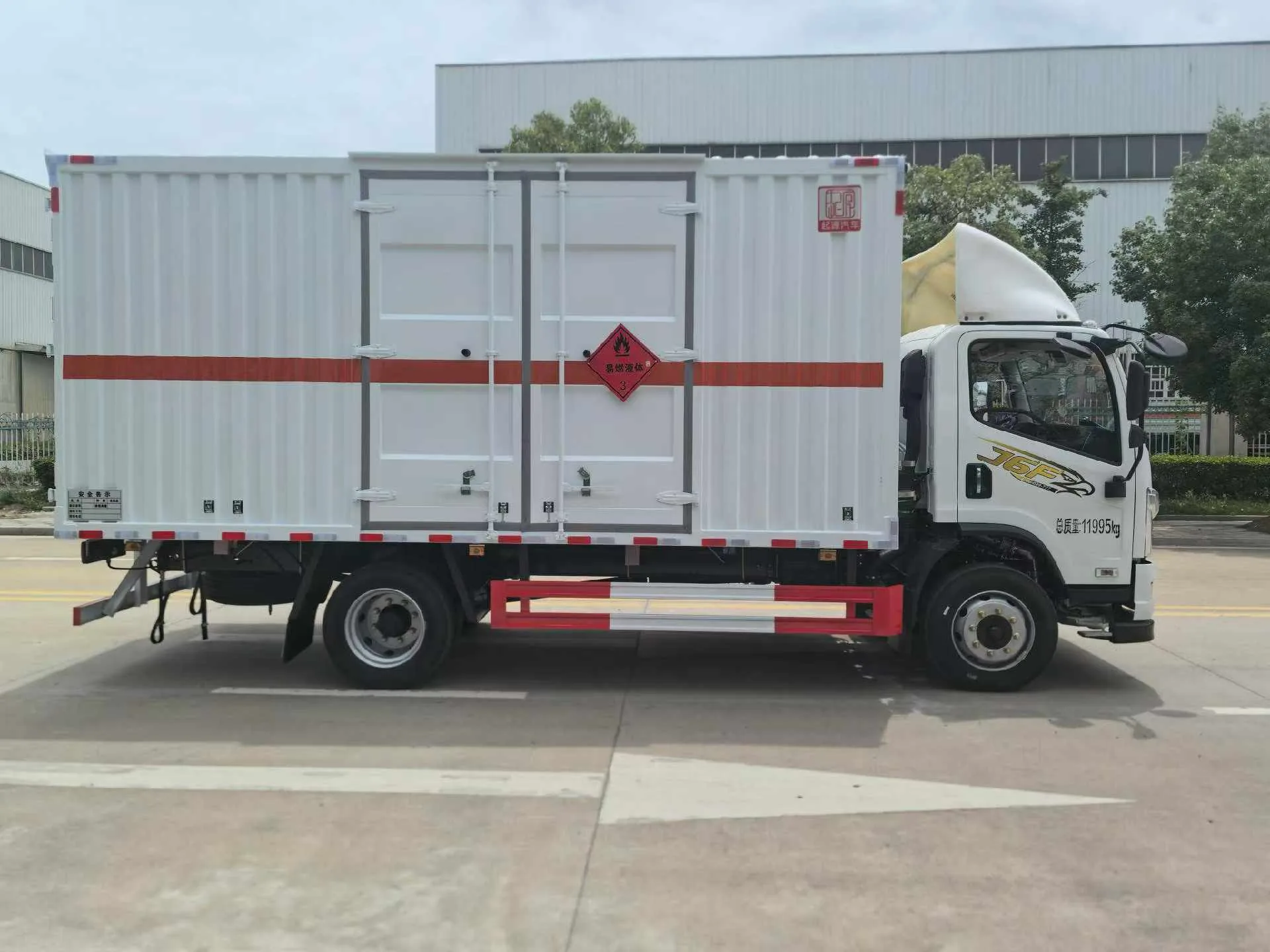 解放J6F黄牌5米2厢长危化品厢式运输车 白色厢体整车右后45度实拍：白色宽体驾驶室 + 白色瓦楞厢体 + 红色反光腰线 + 黄色菱形腐蚀品标识 + 总质量11995kg