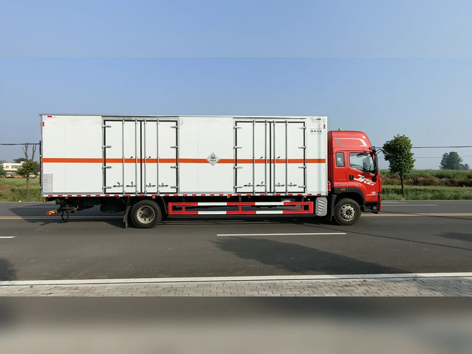 解放JK6单桥危险品厢式运输车 白色平板厢体款式 右侧正侧面实拍：白色厢体带两个侧开门 + 橙色反光腰线 + 红色JK6驾驶室