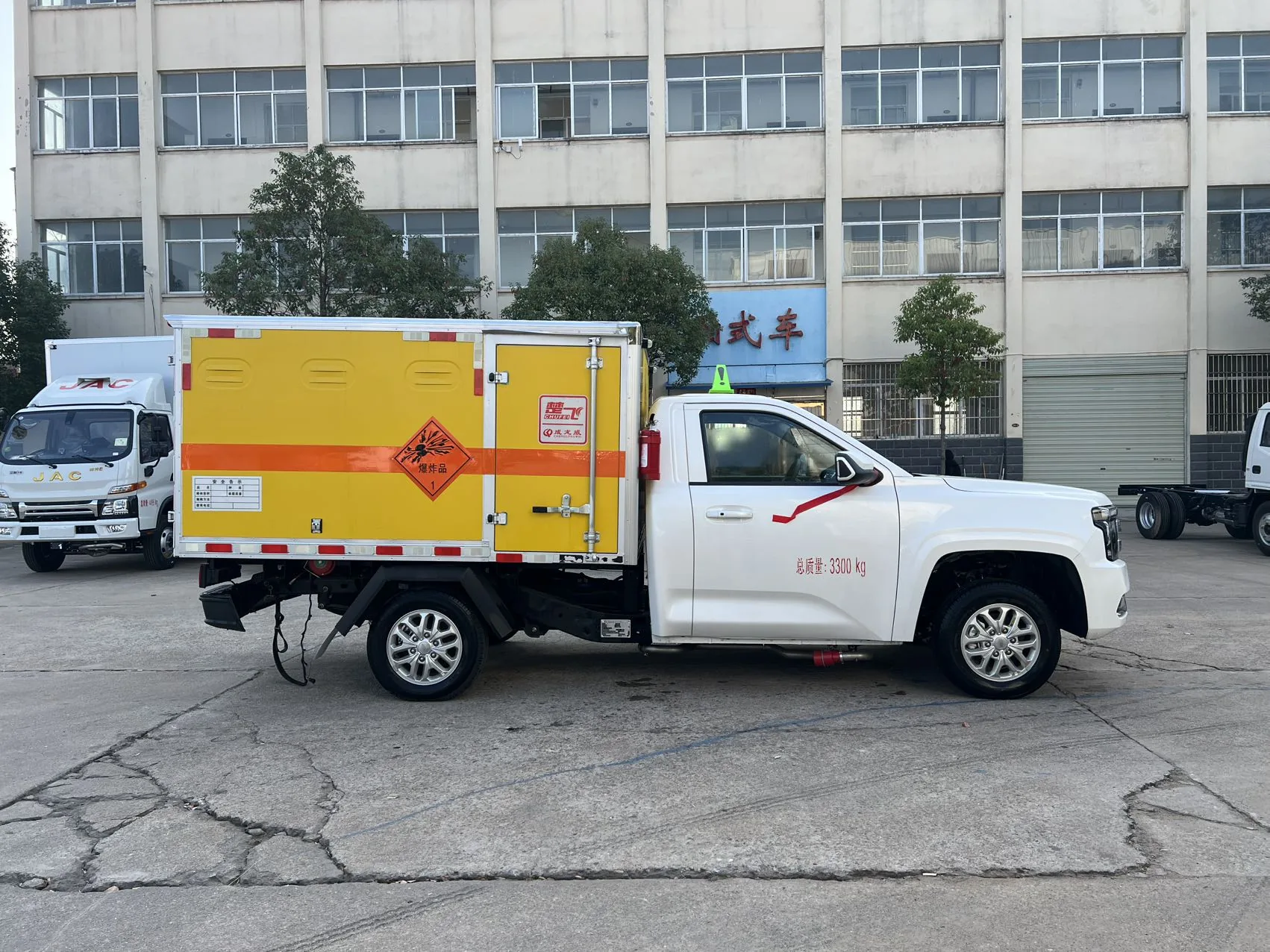 江铃大道皮卡爆破器材运输车 左正侧实拍：黄色厢体 + 爆炸品第1类菱形标志 + 橙色反光带 + 百叶通风窗 + 右侧单侧门 + 驾驶室后挂灭火器 + 总质量3300kg喷字