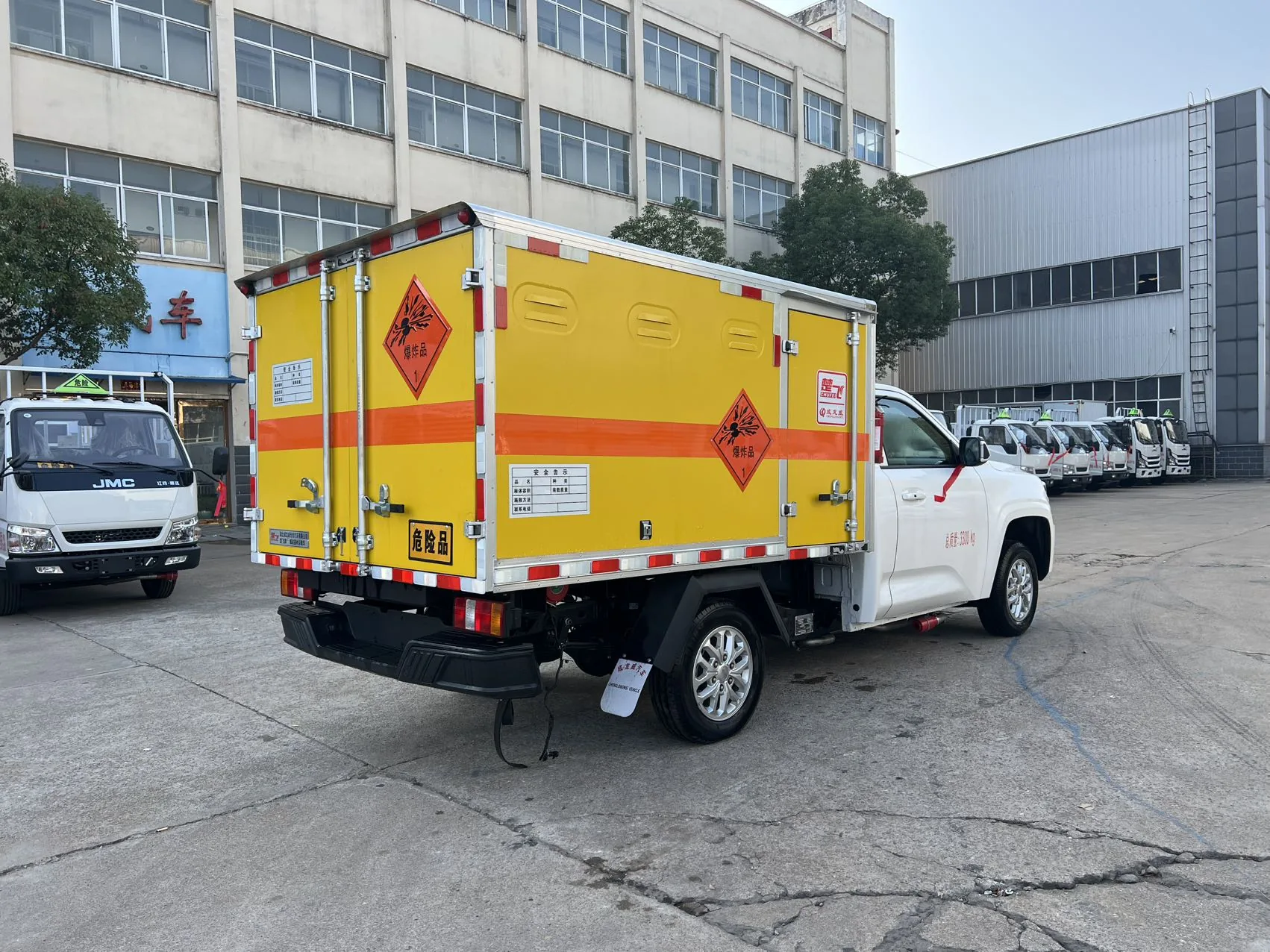 江铃大道皮卡爆破器材运输车 左后45度实拍：厢体后部对开门 + 爆炸品菱形标志 + 危险品安全告示牌 + 门上防盗报警器 + 拖地静电带