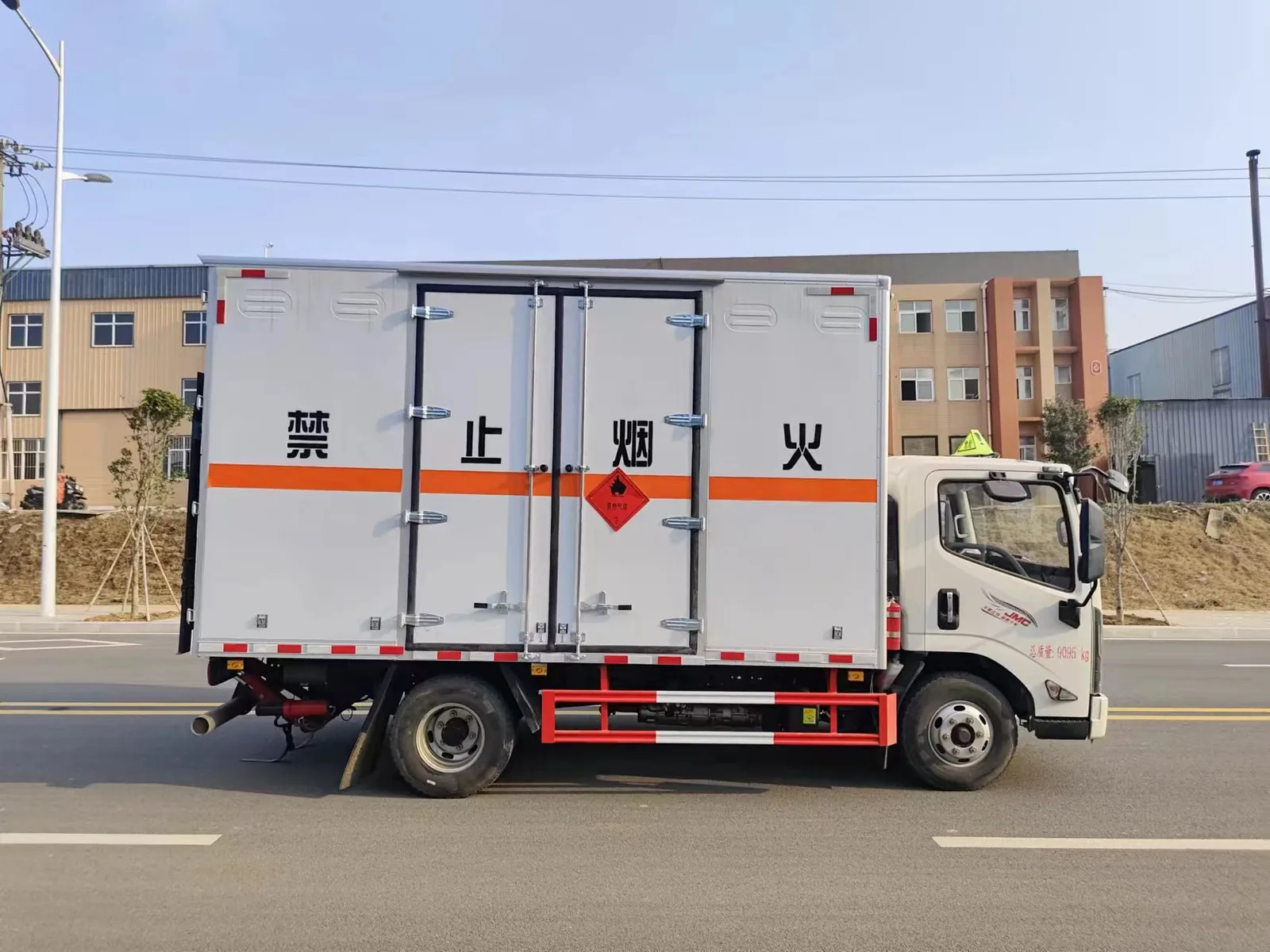 江铃新凯运危险品厢式运输车 正侧面实拍：白色厢体 + 后对开门（一次成型密封胶条+热镀锌门杆）+ 红色菱形标志 + 排气管前置 + 白色排气火花熄灭器 + 红白侧防护栏
